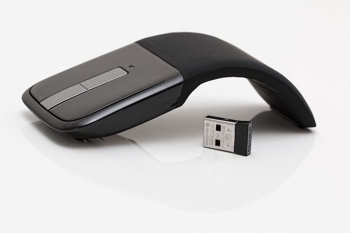 Mouse sem fio com design ergonômico futurista preto em fundo branco.