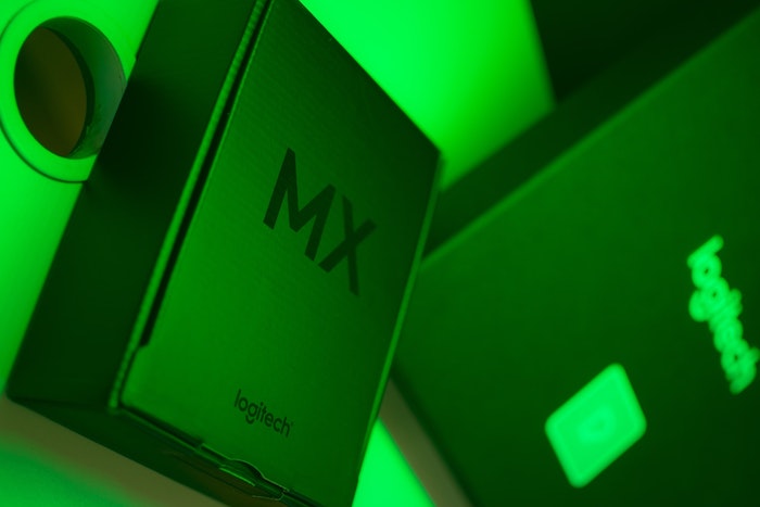 Caixa do mouse sem fio Logitech MX series em um ambiente com iluminação verde.