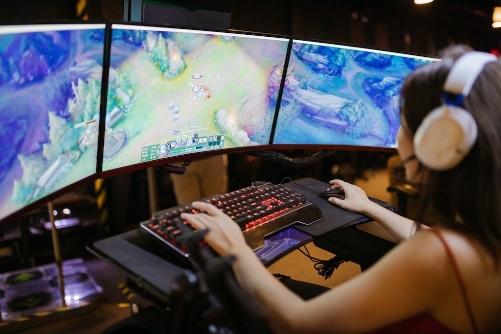 Menina gamer jogando League of Legends em PC gamer.